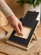 Close-up of a hand loading a treat into the scratch board's pull-out drawer