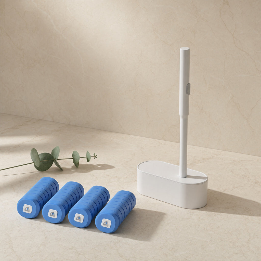 Disposable toilet brush standing in its slim white caddy on a cream studio background