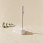White disposable toilet brush and caddy on a cream marble tile — Wombat Haul