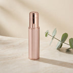 Rose-gold facial hair trimmer standing upright on a cream studio background