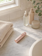 Facial trimmer on a bathroom vanity beside cosmetics — everyday grooming setup