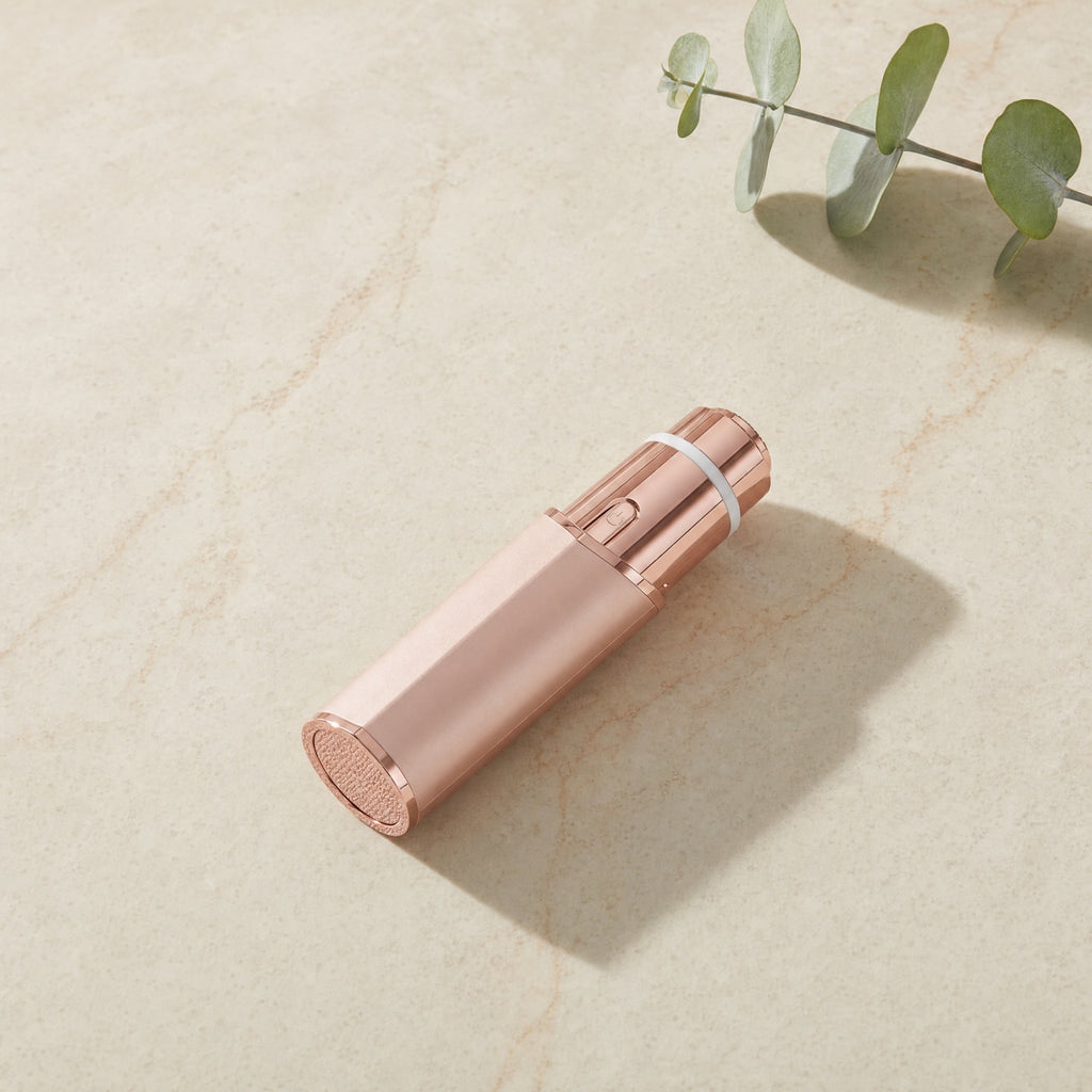 Rose-gold 2-in-1 facial hair trimmer on a cream marble tile — Wombat Haul