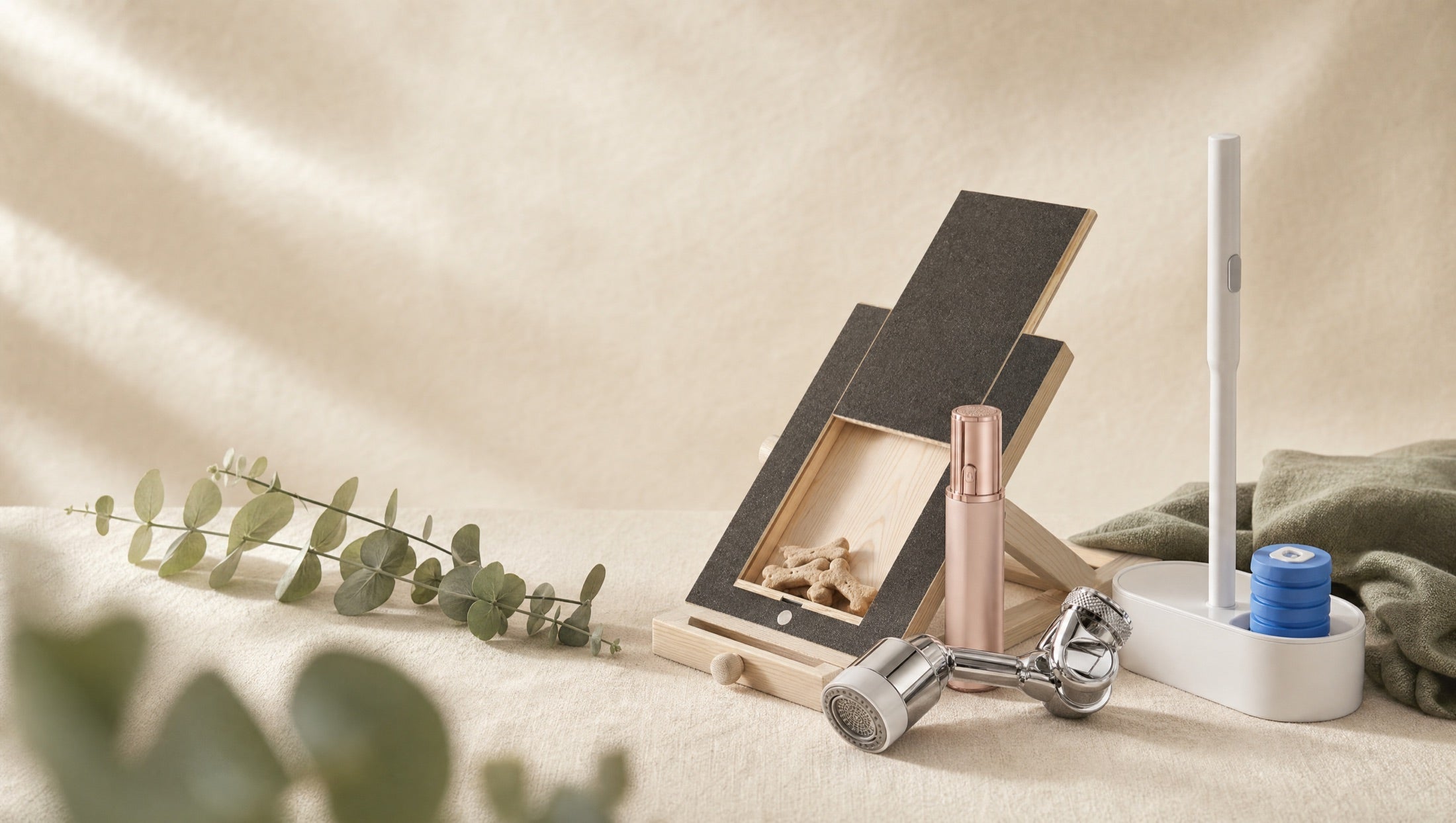 Wombat Haul homepage hero (desktop) — product cluster on cream linen with eucalyptus, clean left half for headline